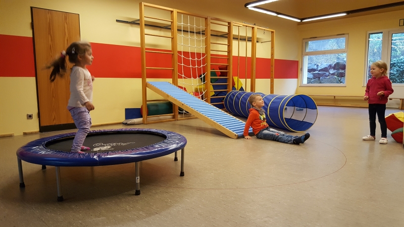 Als anerkannter Bewegungskindergarten werden den Kindern verschiedene Bewegungsimpulse gesetzt, wie hier beispielsweise in unserer Turnhalle mit Trampolin und Rollrutsche.